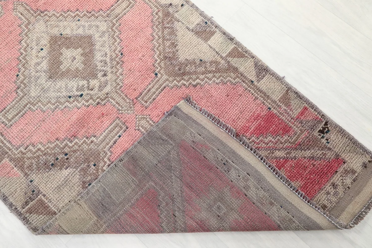 View of the back of the hand-knotted wool runner rug, showing the reverse side of the pattern and cotton foundation.
