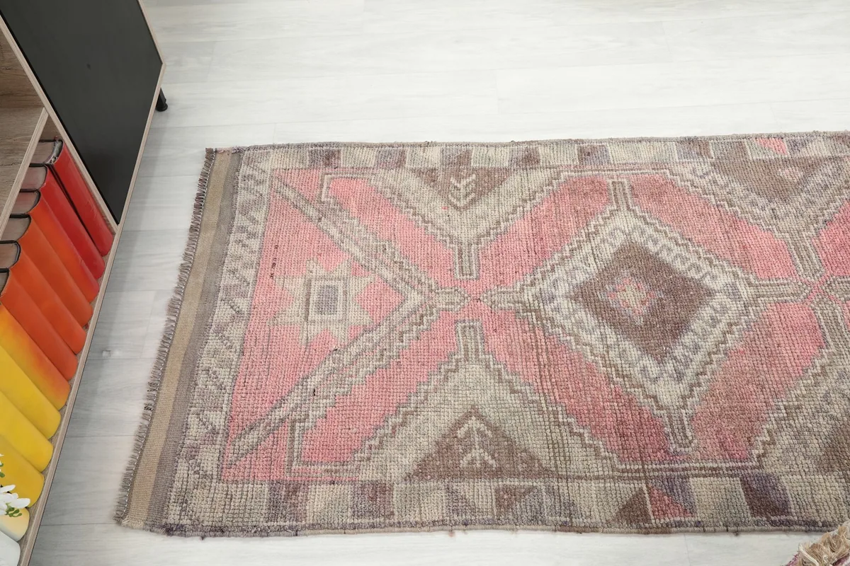 Overhead shot of the rug's middle section, capturing the repeating large geometric diamond patterns.