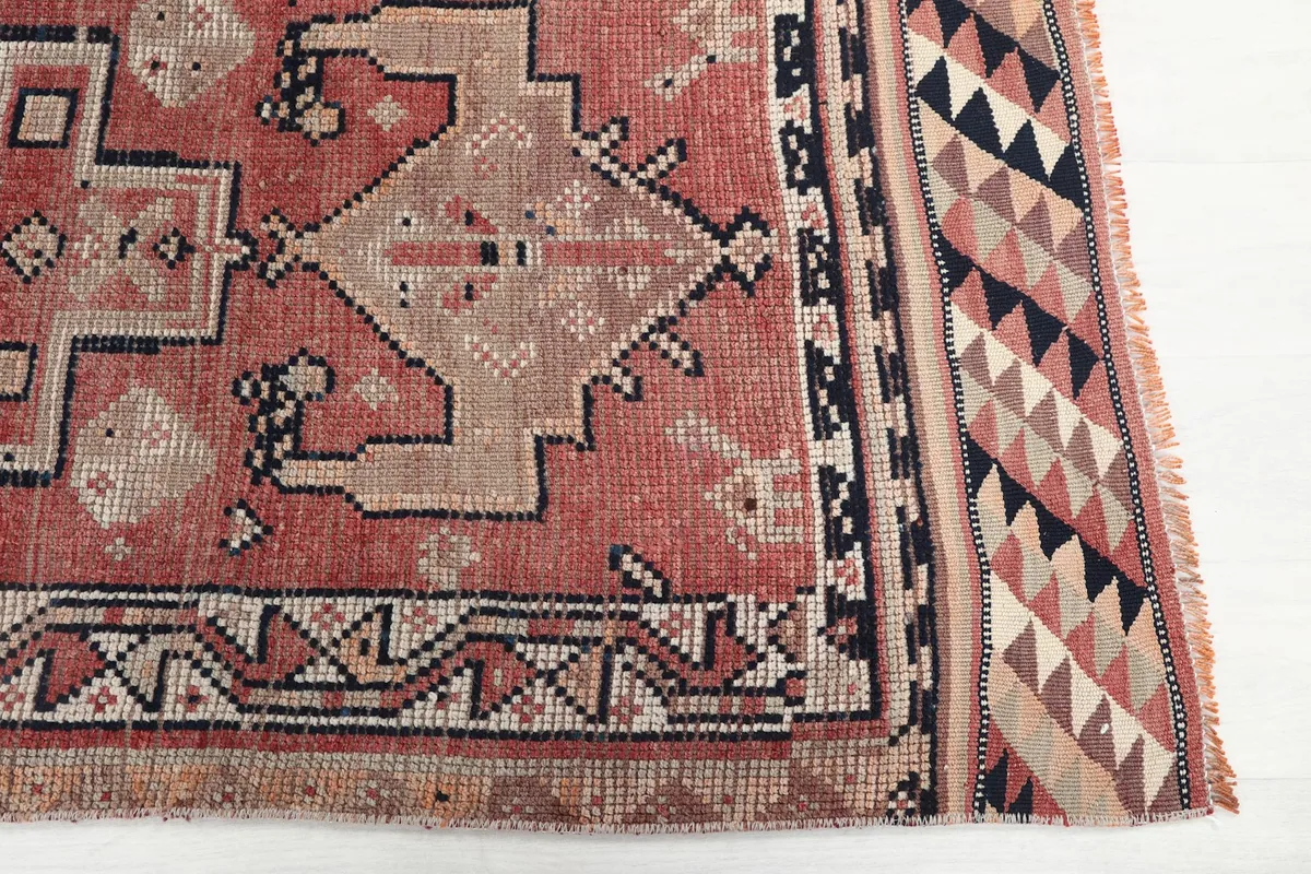 Detailed view of the rust runner rug's border and end design with triangular patterns