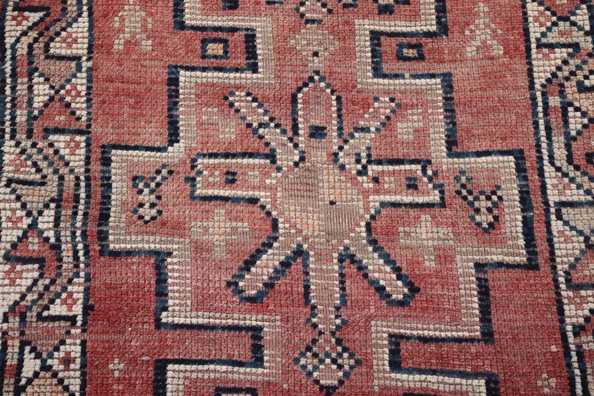 Close-up detail of a central geometric motif on the rust vintage runner rug