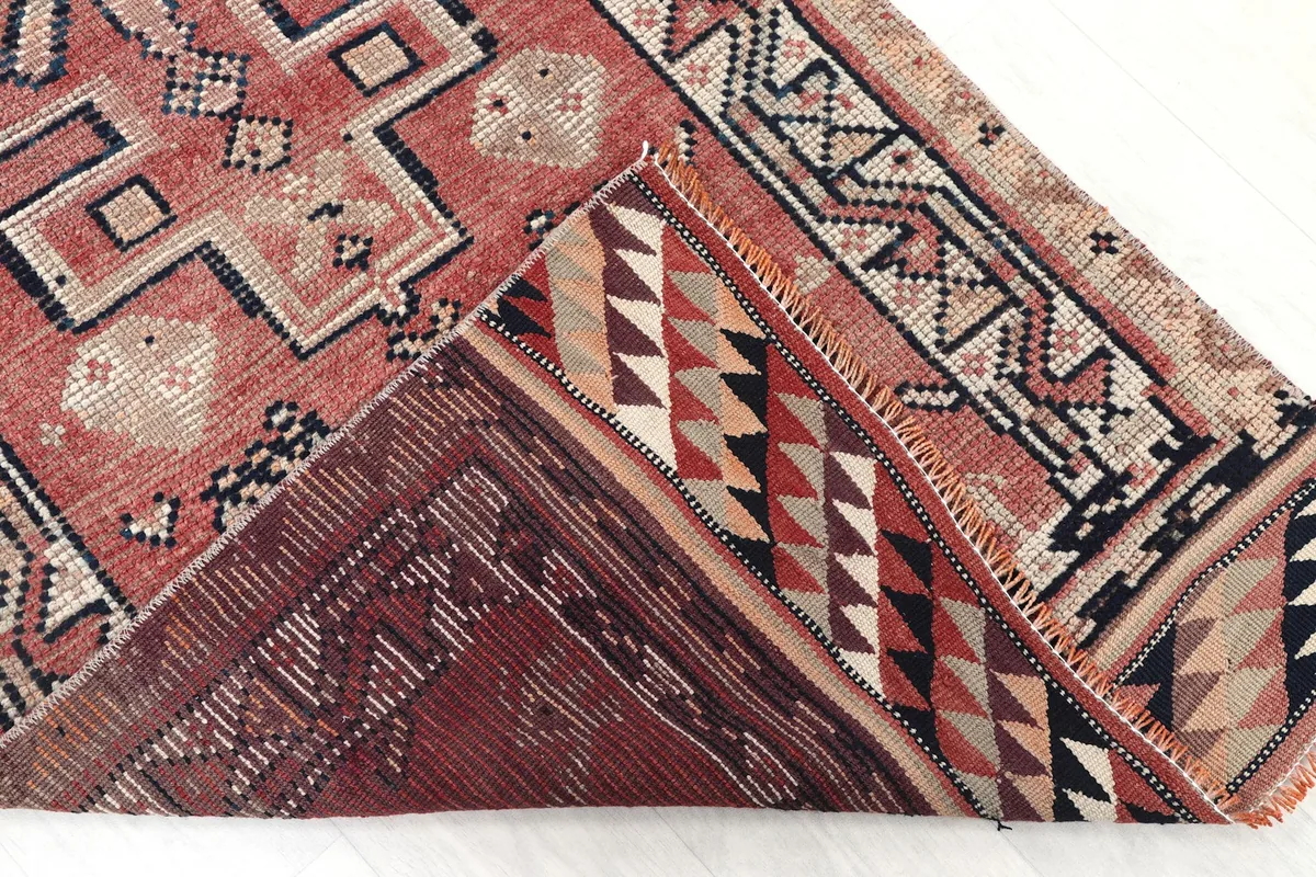 Folded corner of the rug, revealing the hand-knotted backing and construction