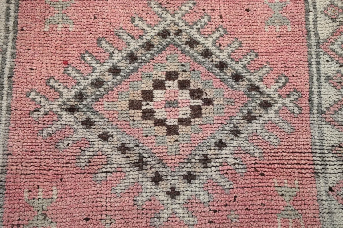 Detailed view highlighting the texture of the wool pile and the colors of the geometric design