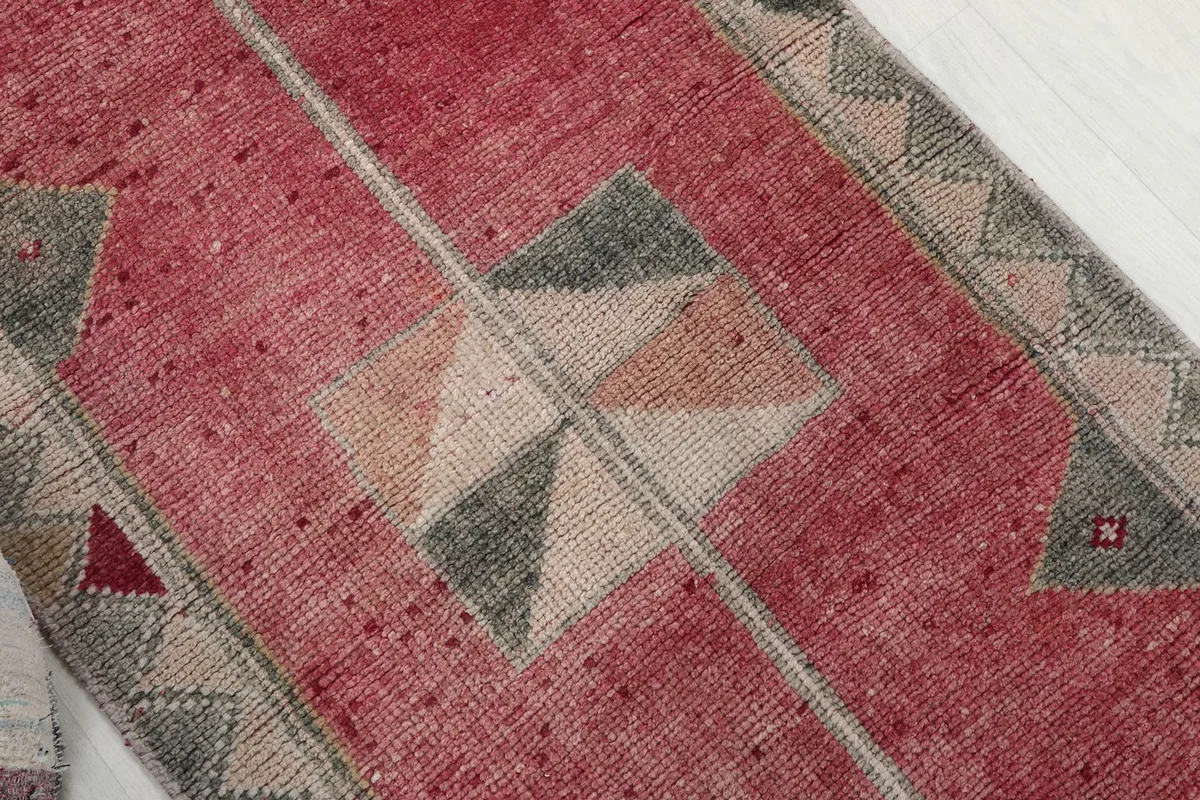 Overhead angle showing the central geometric motifs and the rose field of the rug.