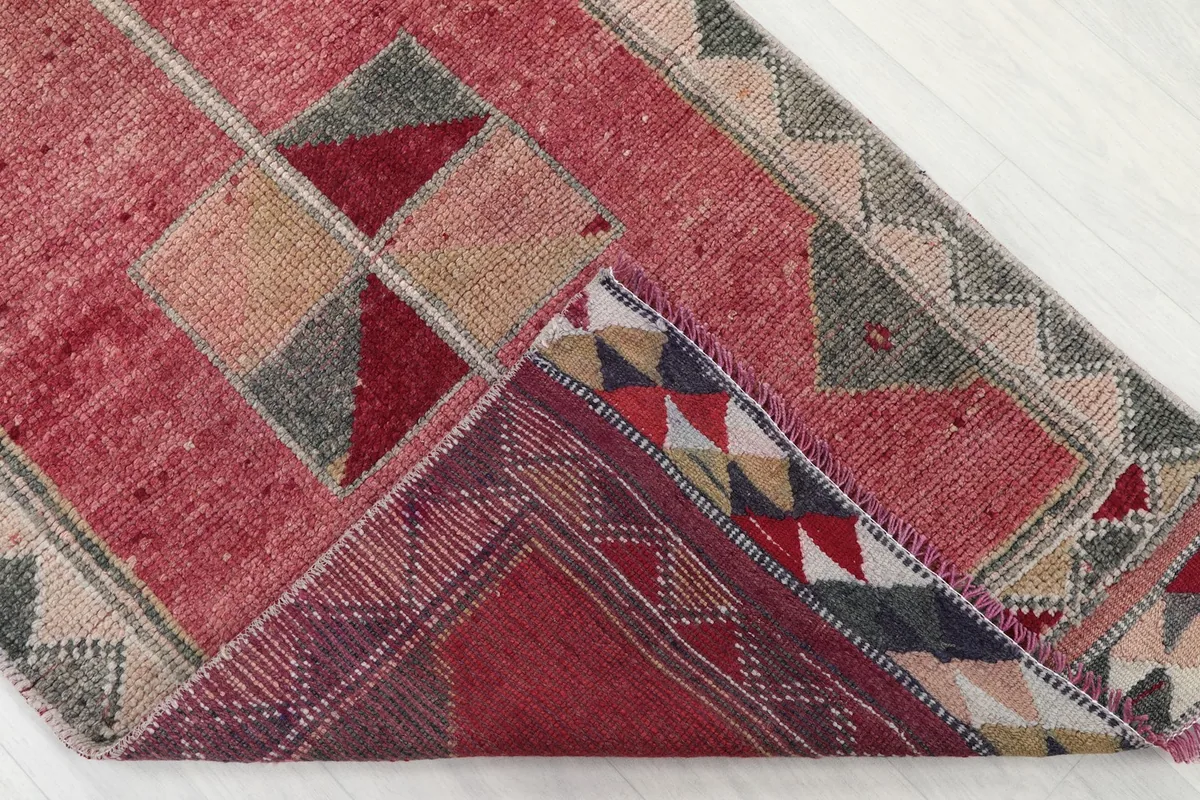 Corner of the rug folded back, revealing the reverse side and knotting details.