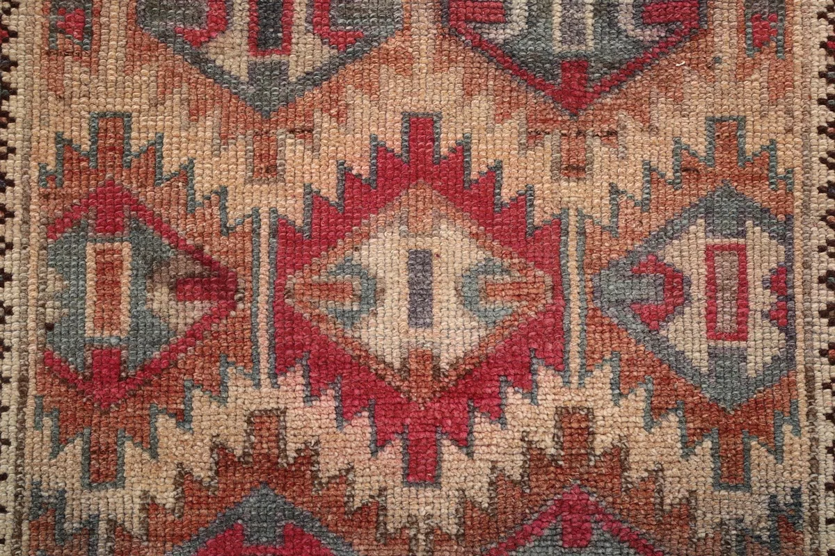 Overhead close-up of the intricate red, blue, and beige tribal patterns