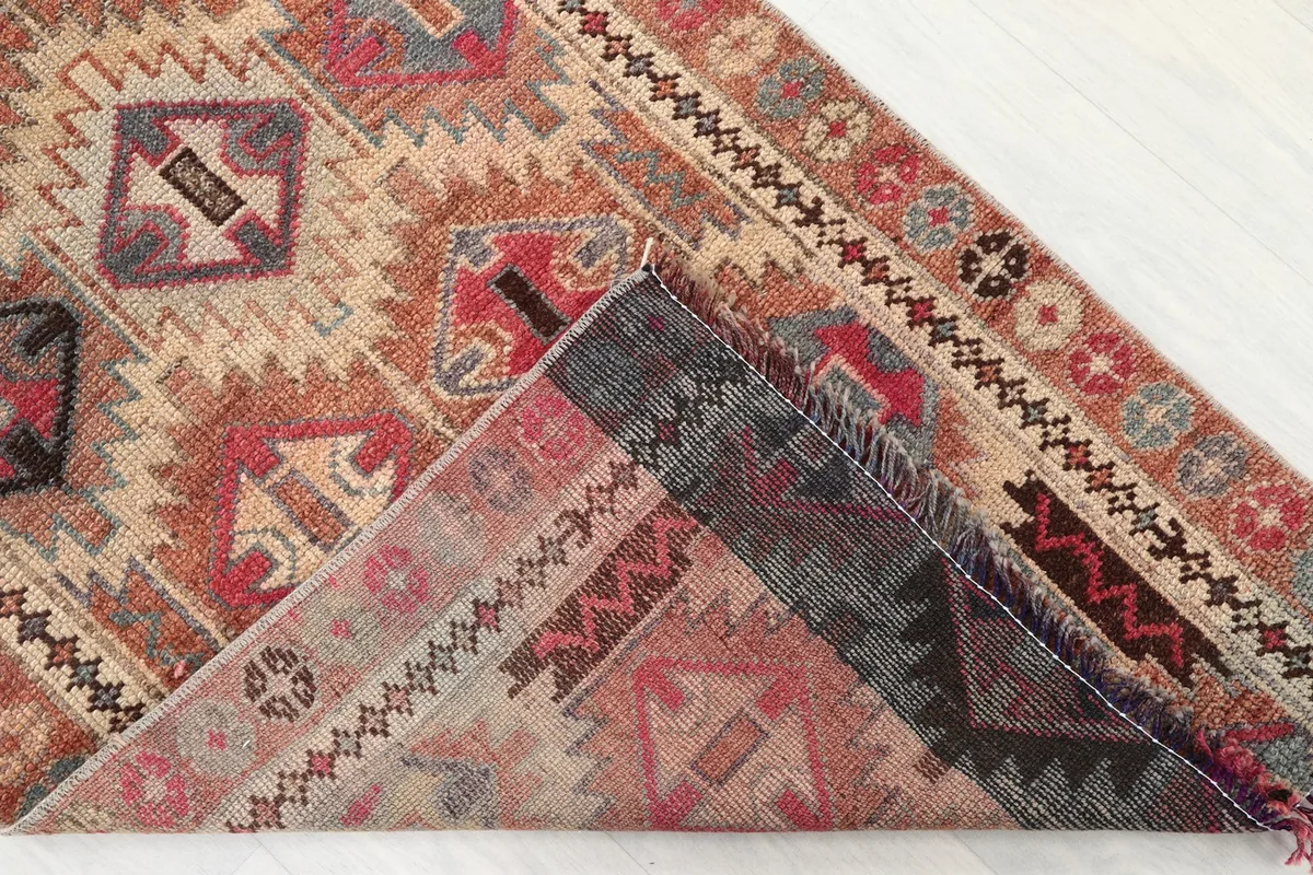 Underside of the rug folded back, revealing the hand-knotted cotton foundation