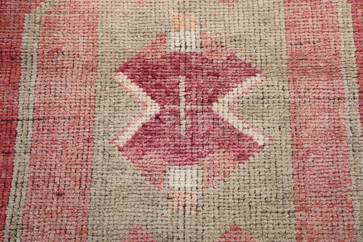 Close-up of the rug's low wool pile, showing individual knots and color variations