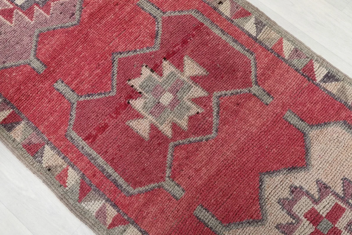 Diagonal view highlighting the rose field and beige geometric patterns of the runner