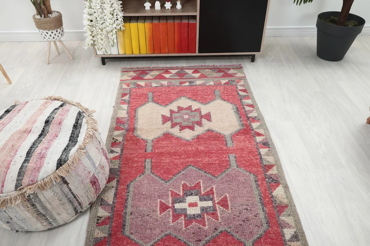 Overhead view of the runner rug in a room, showing its placement relative to a pouf and cabinet