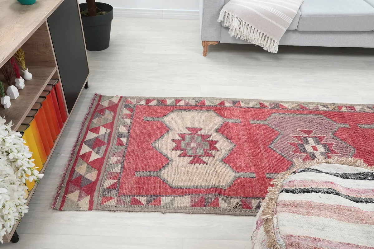 Angle view of the runner rug extending from a cabinet towards a sofa