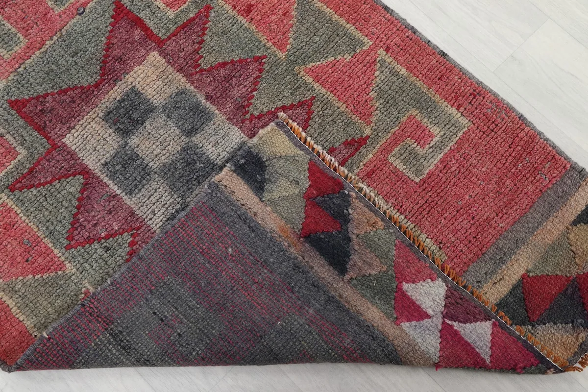 Corner of the runner folded to reveal the hand-knotted cotton foundation and reverse side