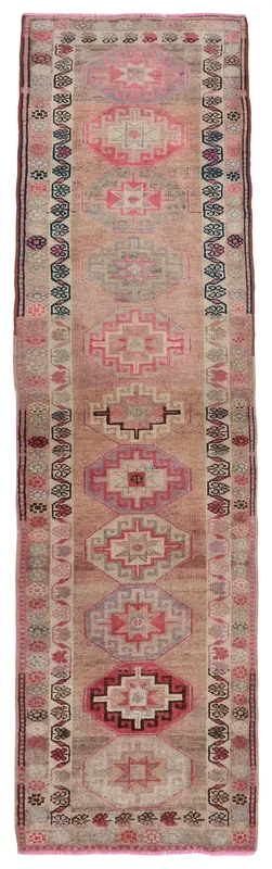Full top view of the beige and rose tribal medallion vintage Anatolian runner rug on a white background.