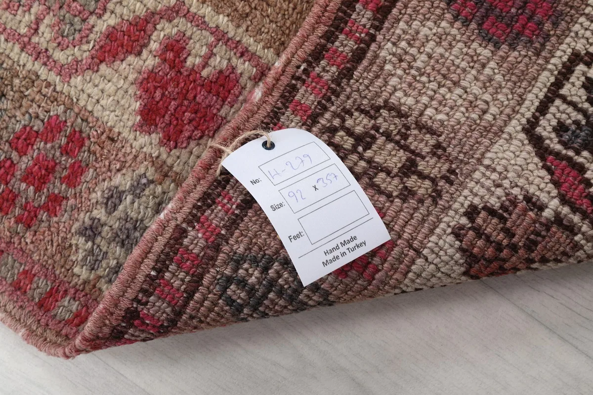 Corner of the rug with a tag displaying size 3'0" x 11'9" (92 x 357 cm) and 'Hand Made in Turkey'.