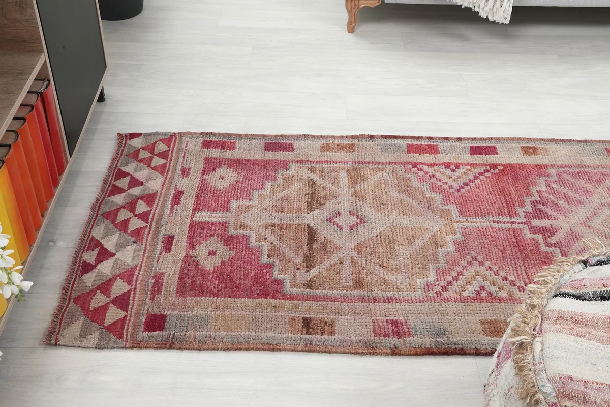 Angled perspective of the runner rug, showing the blend of rose, tan, and beige tones
