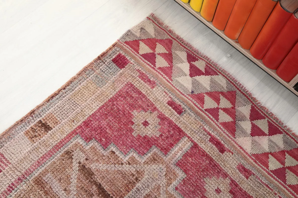 Close-up of the rug's border design, featuring geometric shapes and color transitions