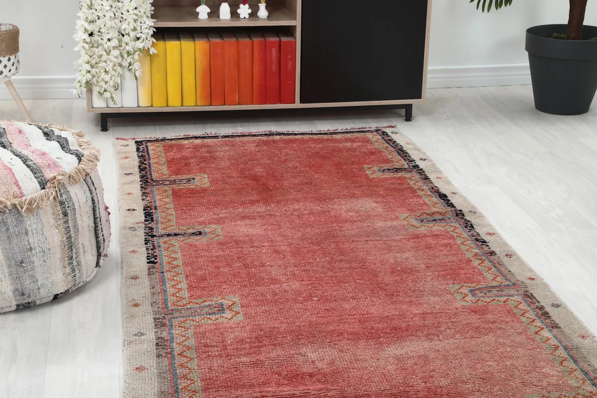 Closer view of one end of the rose runner in a room, showing the beige border and geometric details.
