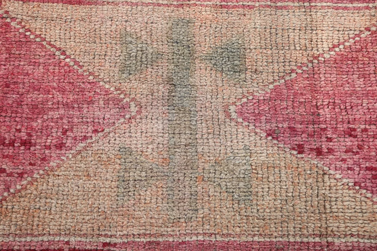 Extreme close-up of a tribal motif within the rug, showcasing the wool pile and color variations