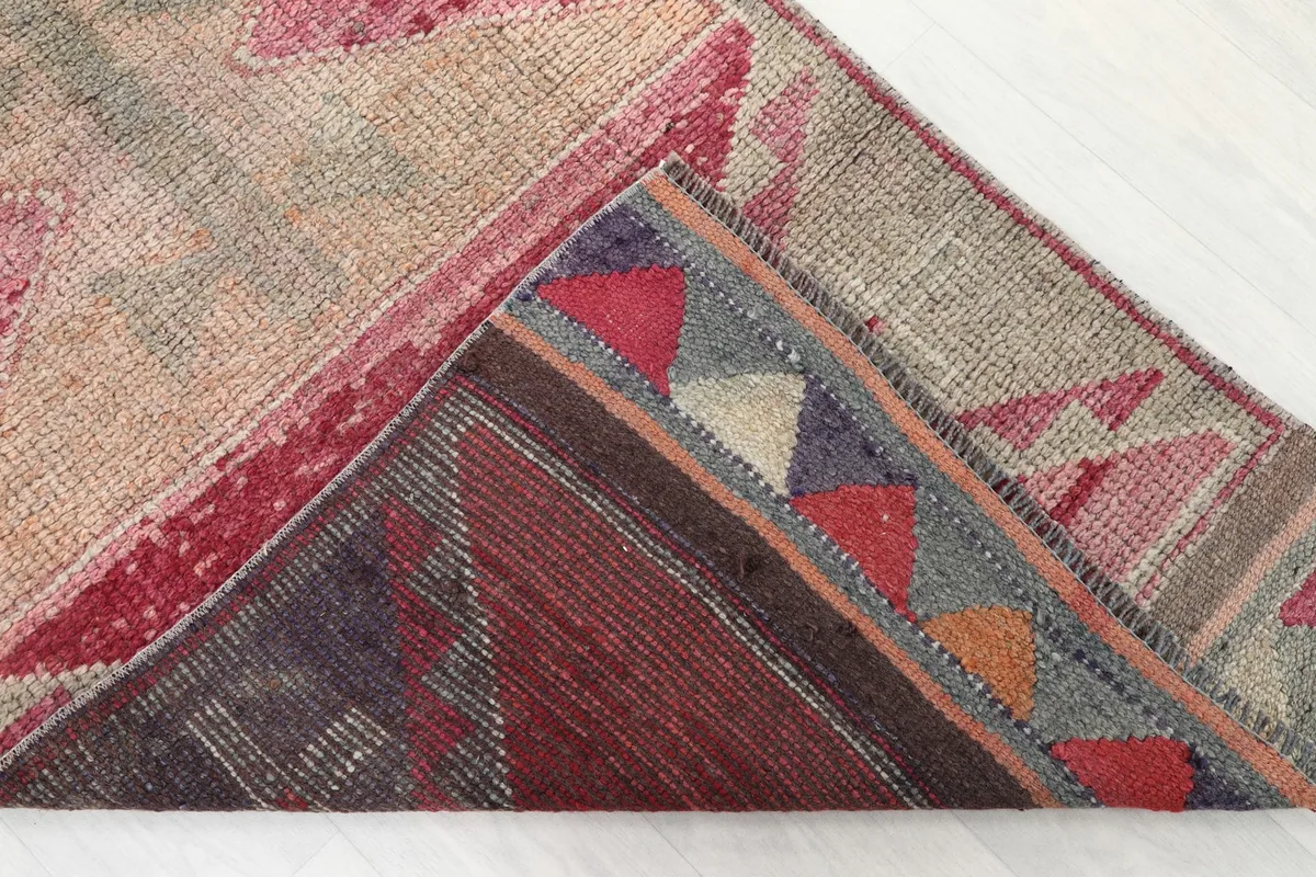 View of the back of the runner rug, revealing the hand-knotted cotton foundation and wool pile