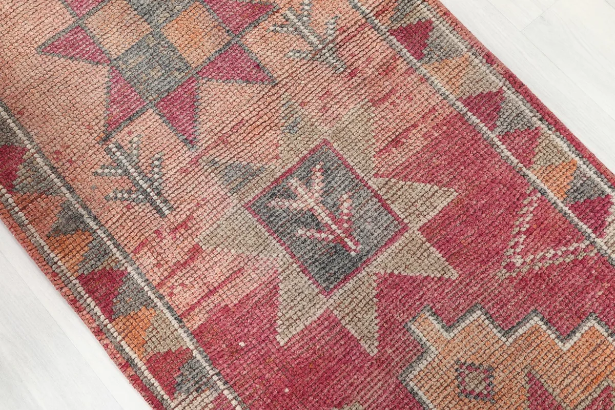 Close-up of a central geometric star motif in rust, red, and gray tones.