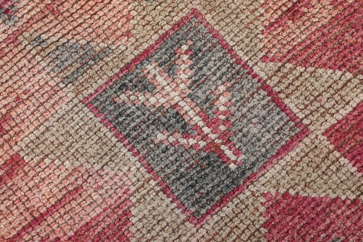 Textural close-up showing the low wool pile and intricate knotting of the rug.