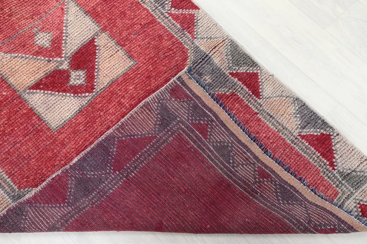 Corner of the rug folded to show the cotton foundation and reverse side