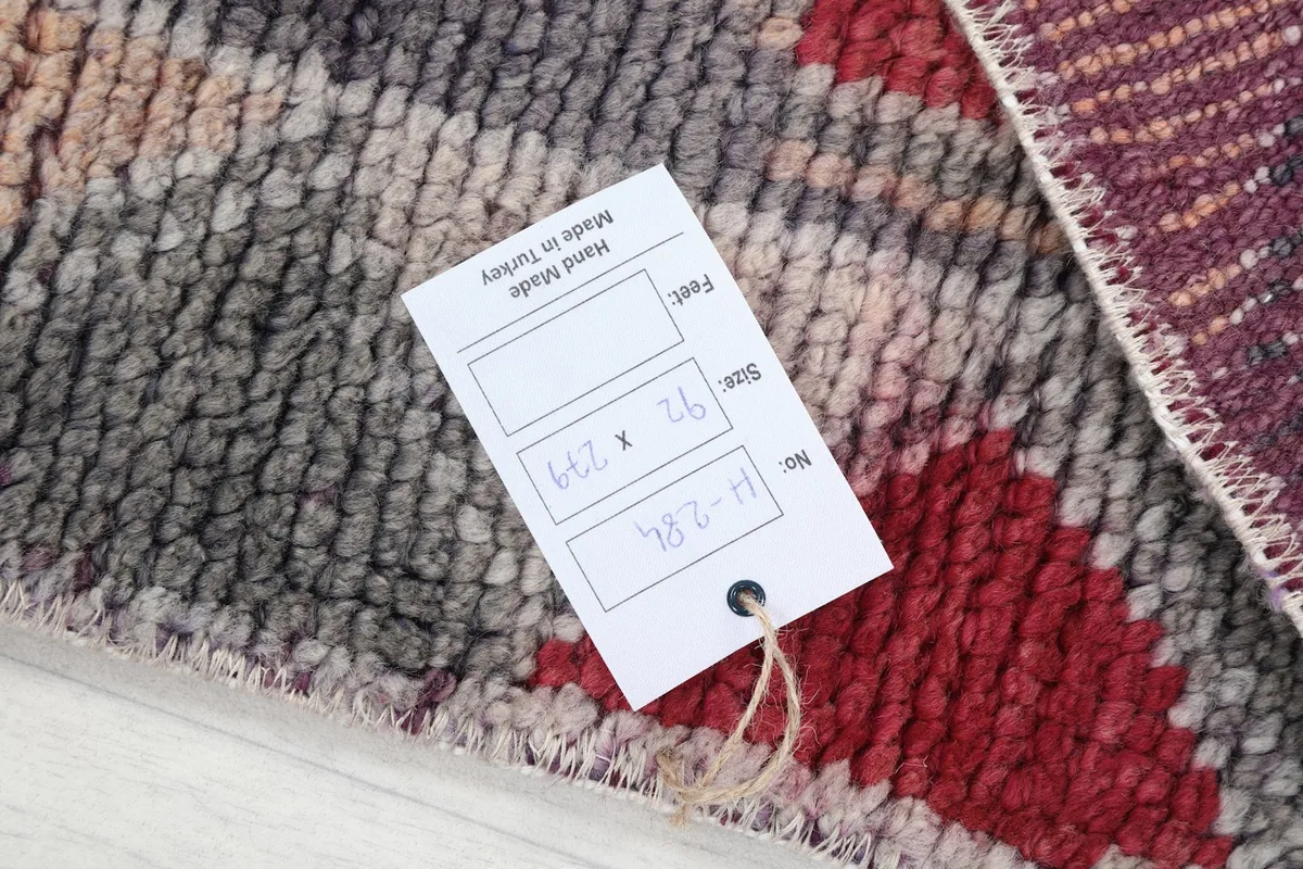 Close-up of the rug's texture with a size tag showing 92 x 279 cm