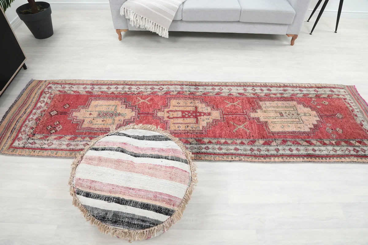 Full length view of the red and tan runner in a room, demonstrating its scale next to furniture