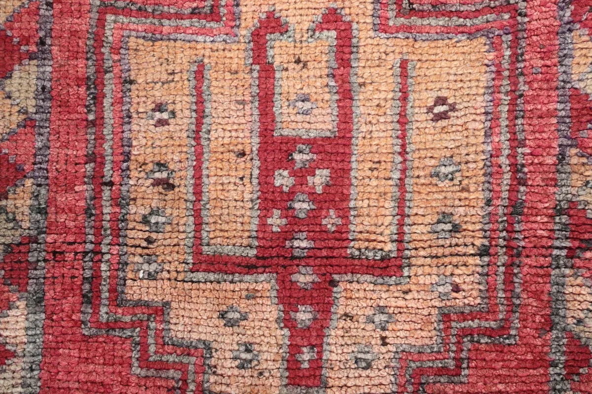 Macro detail of the hand-knotted wool pile, revealing intricate geometric shapes and color blend