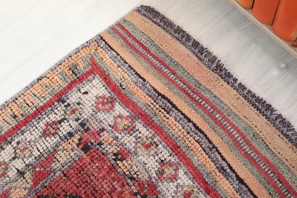 Corner detail of the runner's border, showcasing the striped and patterned edges