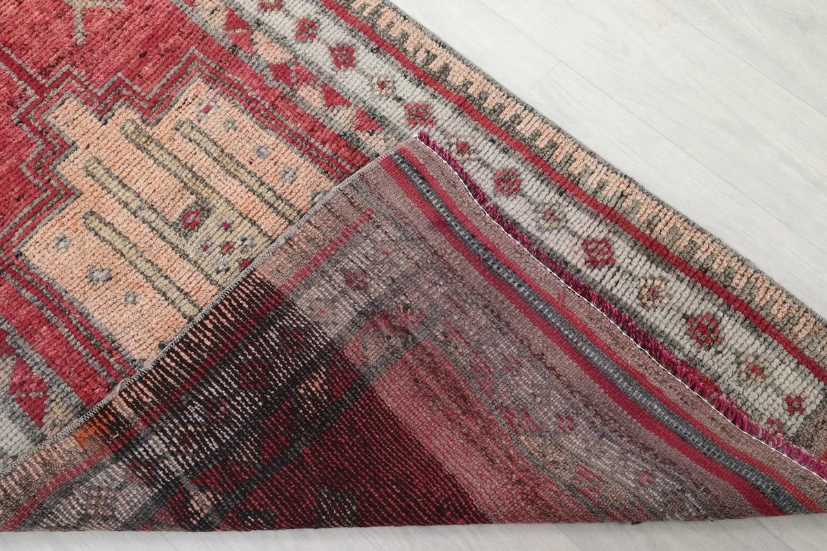 Folded corner of the rug, revealing the wool pile and cotton foundation structure