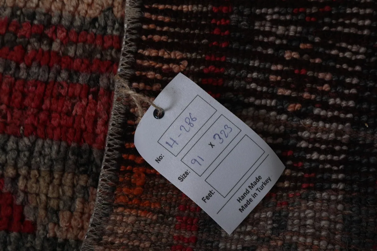 Product tag showing the rug's size in centimeters and feet, confirming hand-made in Turkey origin
