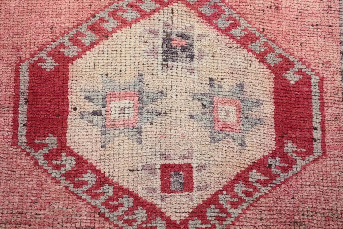 Macro detail of the central geometric medallion, revealing the intricate hand-knotted wool texture.