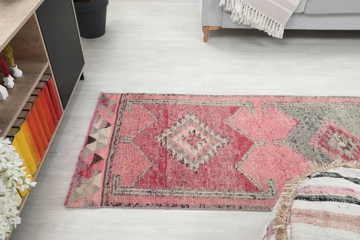 Long view of the runner rug stretching across a room, from a slightly elevated perspective