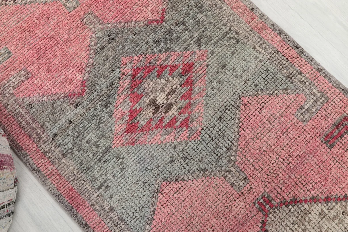 Close-up of the central geometric motif in rose, gray, and red on the runner
