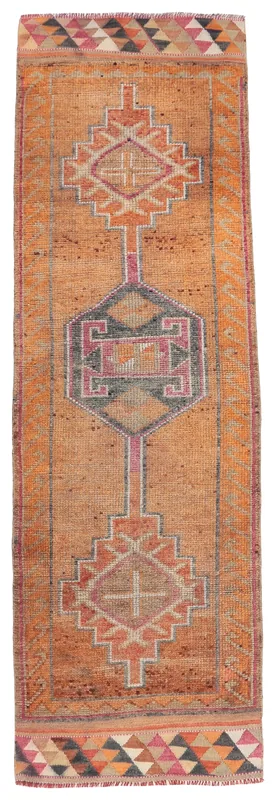 Full overhead view of the orange geometric Anatolian runner rug on a white background