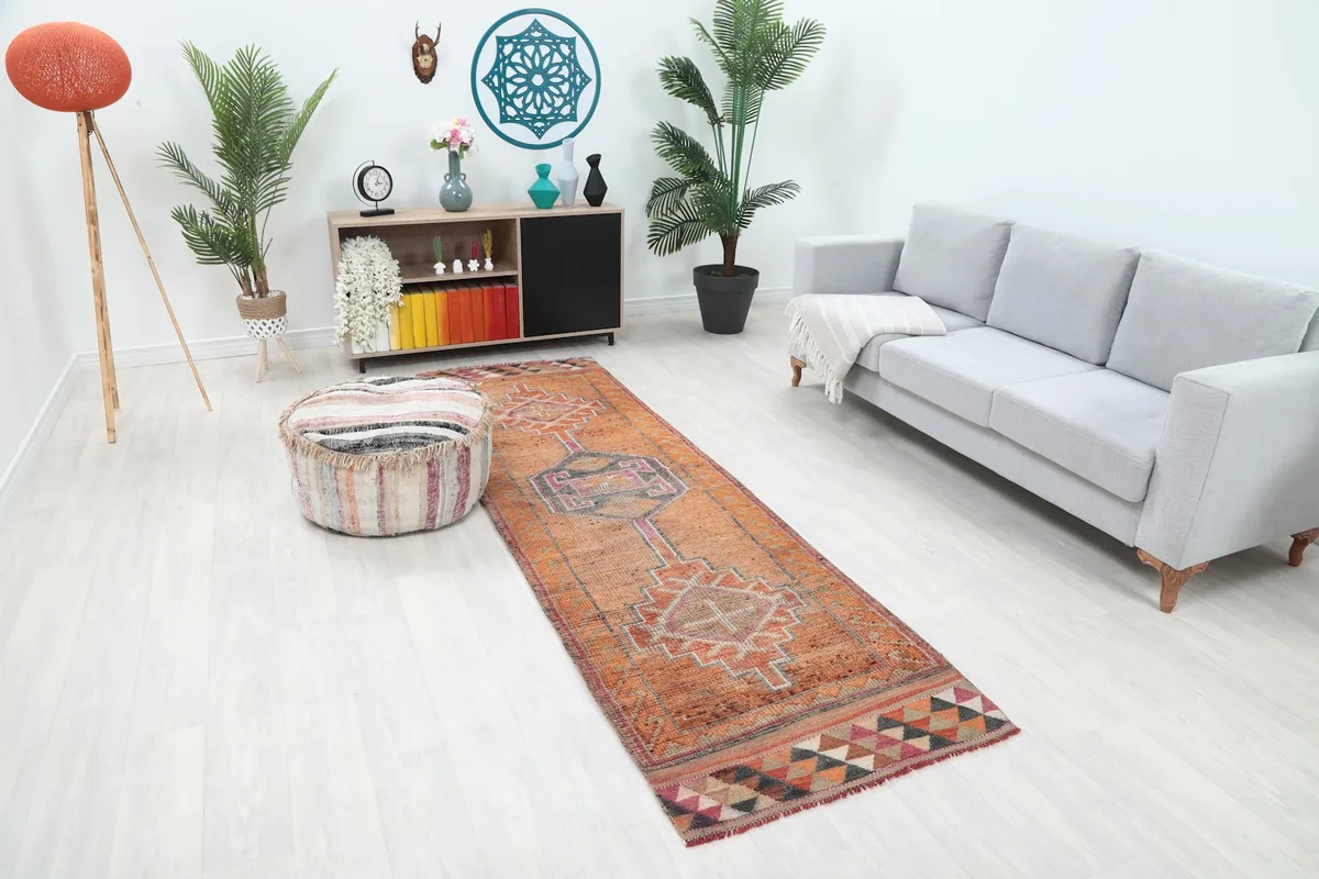 Angle view of the orange geometric runner rug in a room setting, showcasing its length