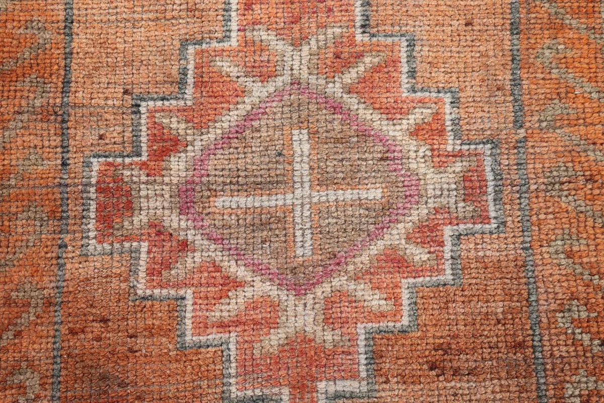 Detailed view of the hand-knotted wool pile and intricate geometric design elements