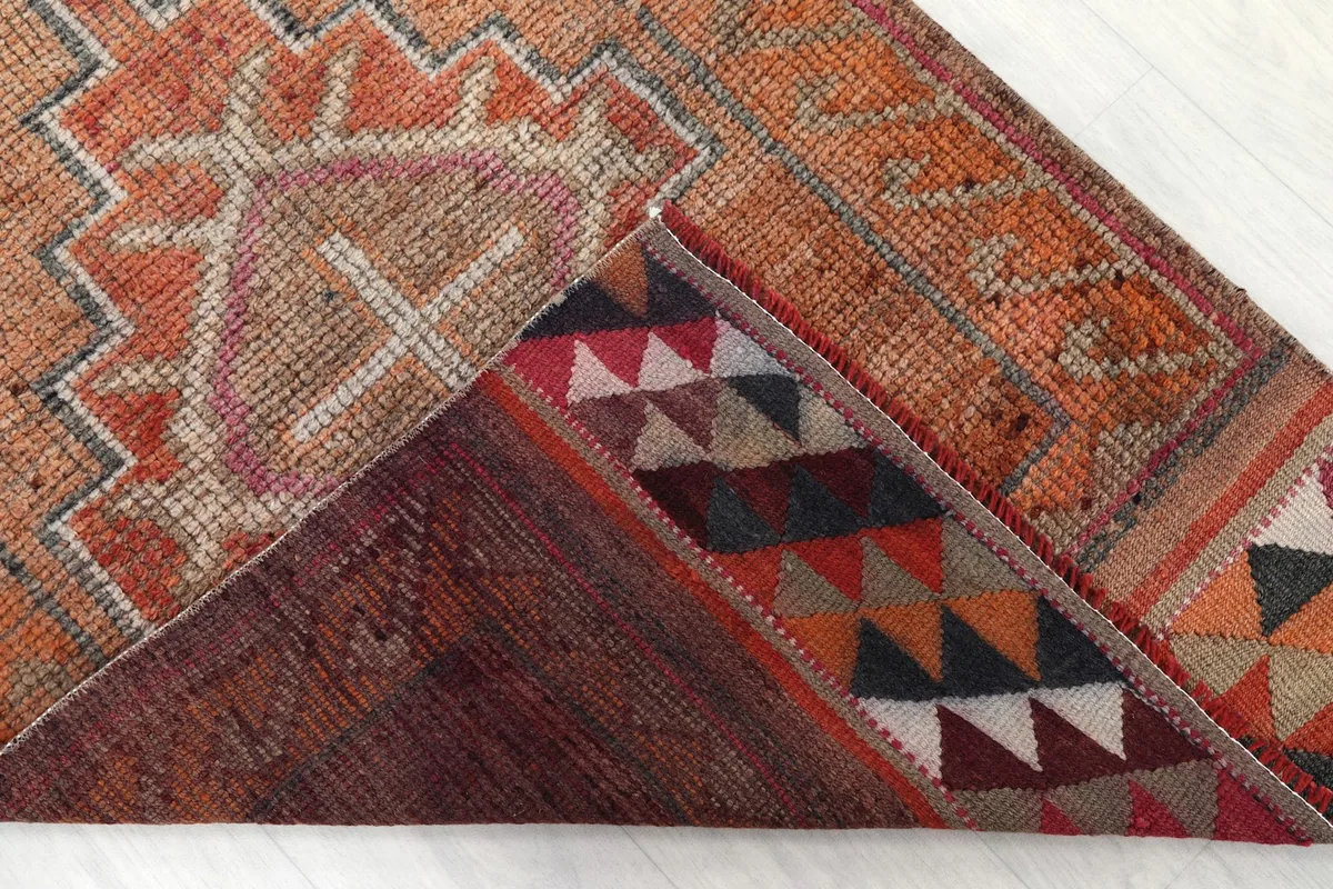 Corner folded back to show the cotton foundation and the reverse side of the hand-knotted rug
