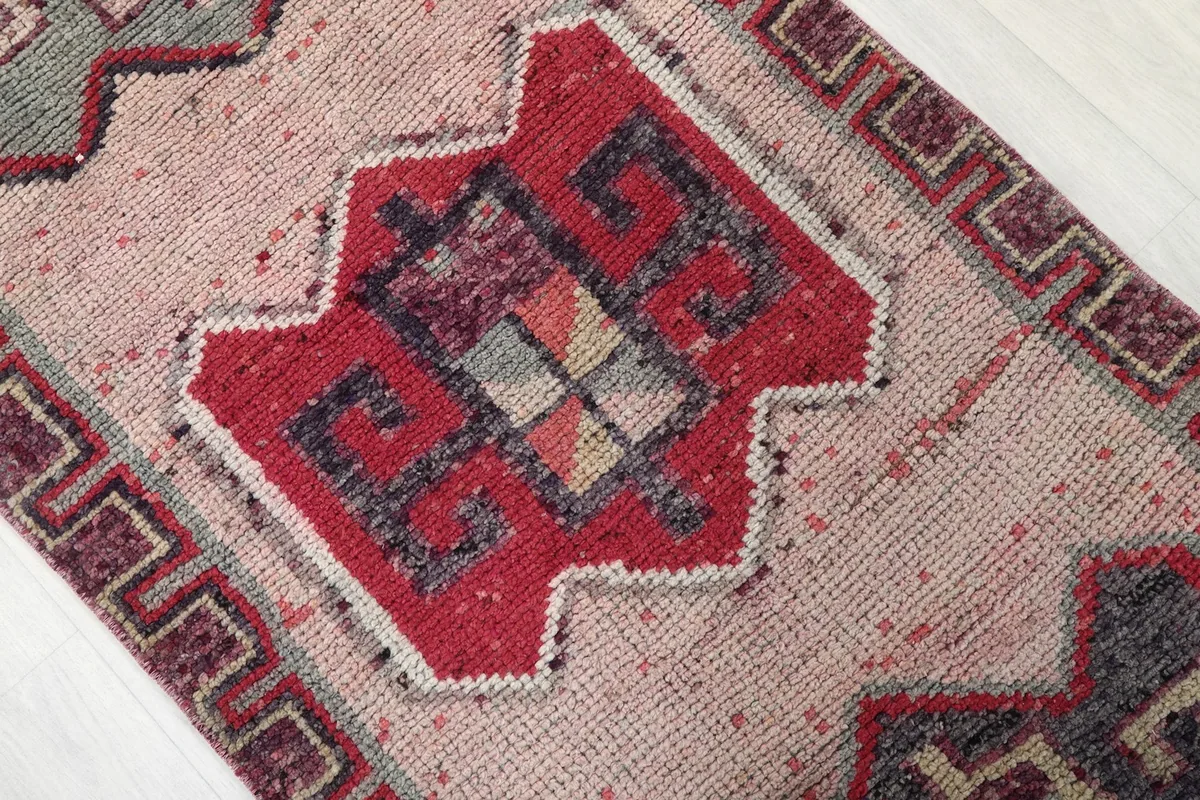 Detailed view of a red geometric medallion on the beige field of the runner