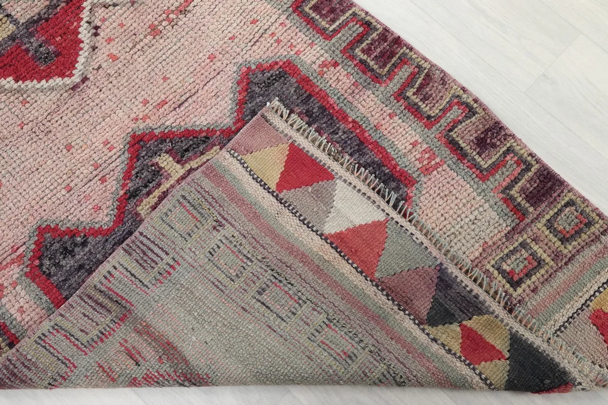Folded corner of the rug revealing the backside (foundation) and pile texture