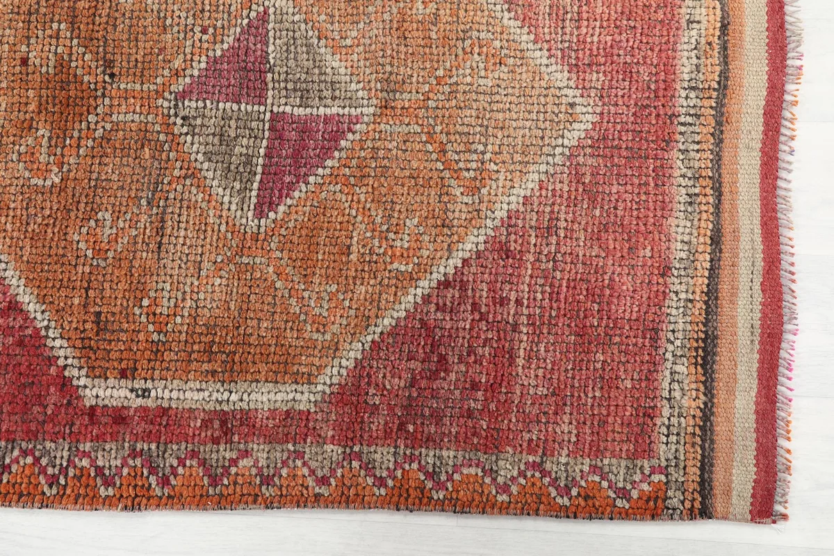 Detailed view of the rust field and orange geometric motif with border