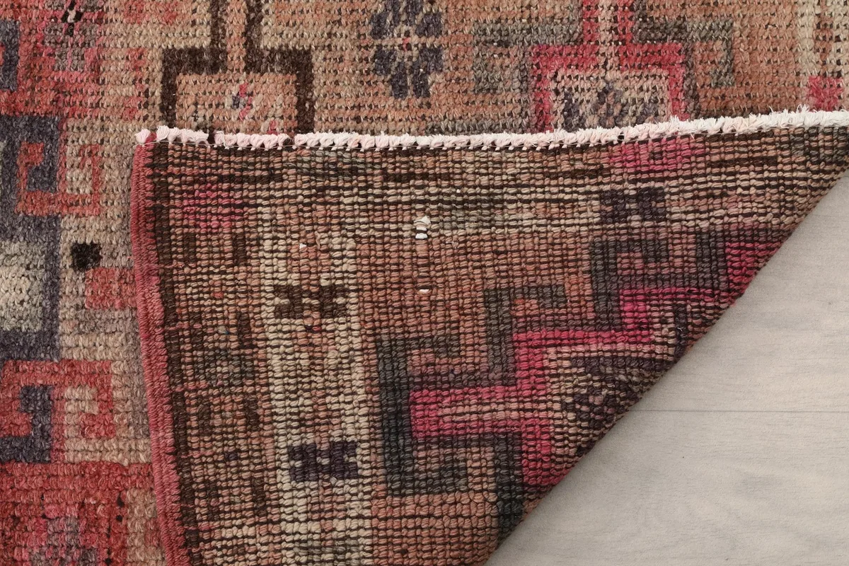 Close-up of the rug's reverse side, showcasing the tight weave of the cotton foundation and the knotting structure