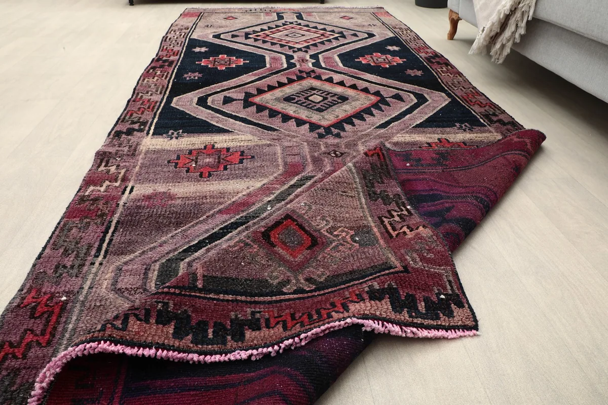 Runner rug partially folded, displaying its full length and construction