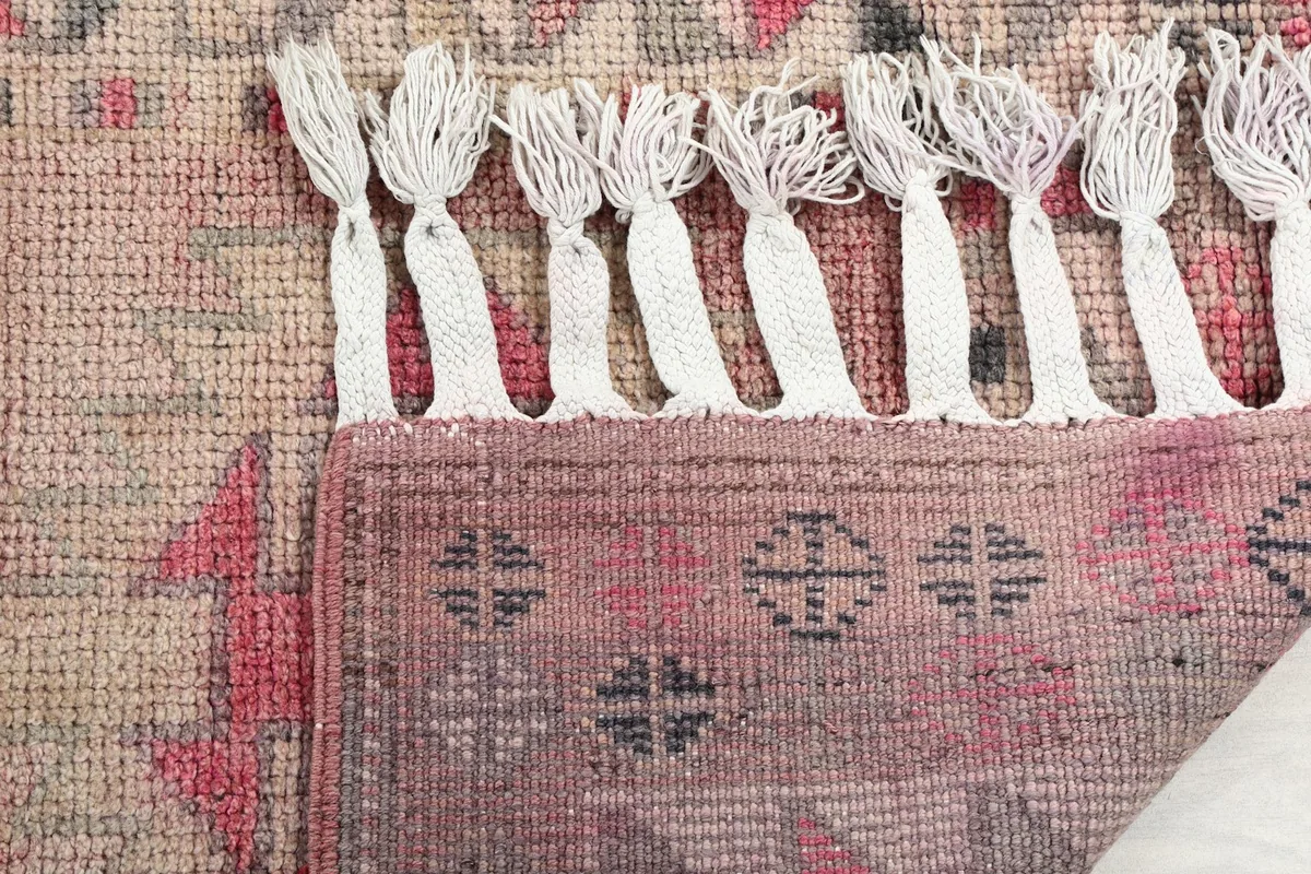 Close-up of the rug's fringe and the reverse side, showing craftsmanship.