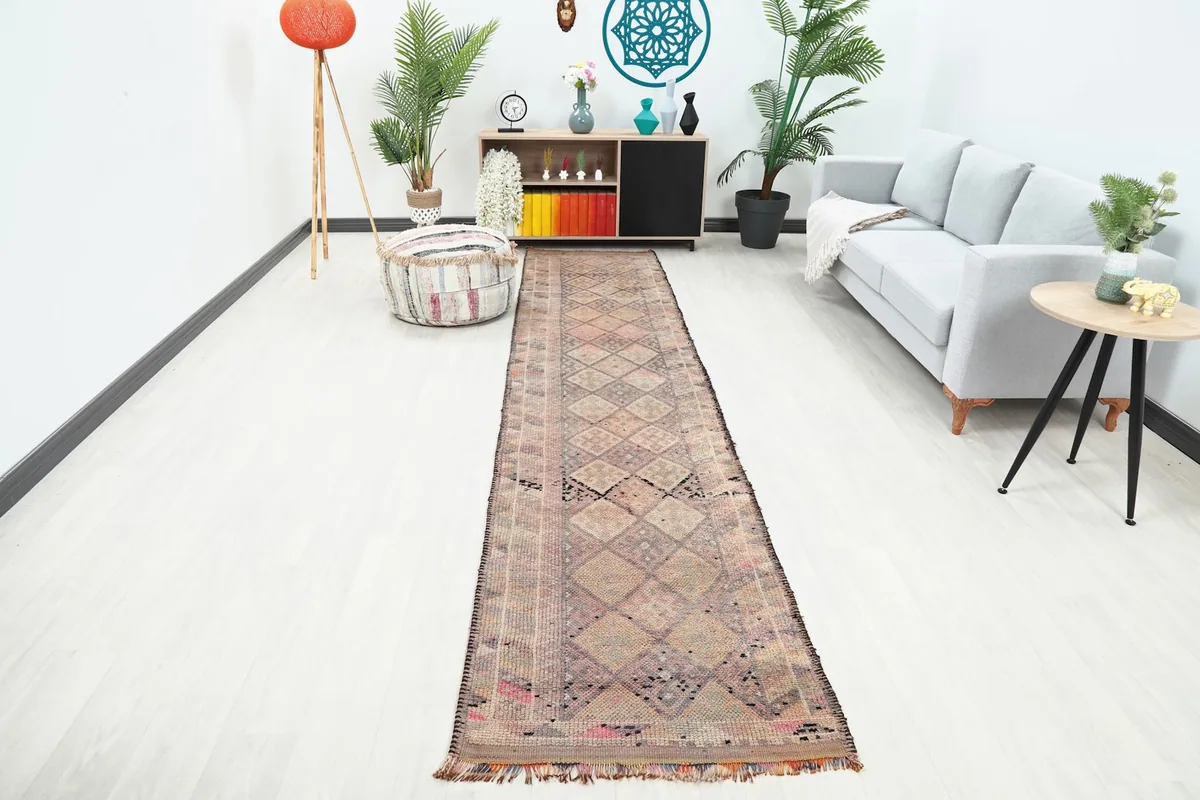Long runner rug laid out in a modern room with a gray sofa and wooden furniture
