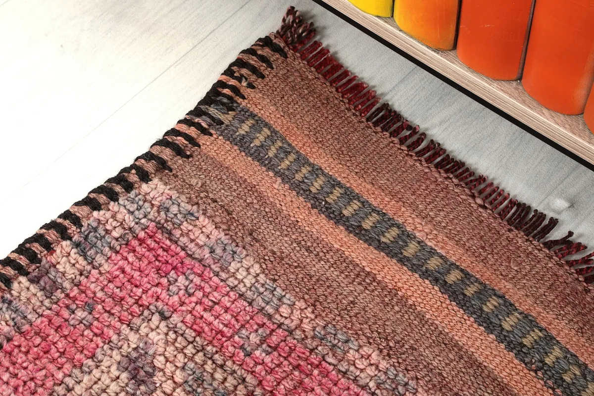 Close-up of the end border and selvedge of the faded red runner, showing brown and gray stripes.
