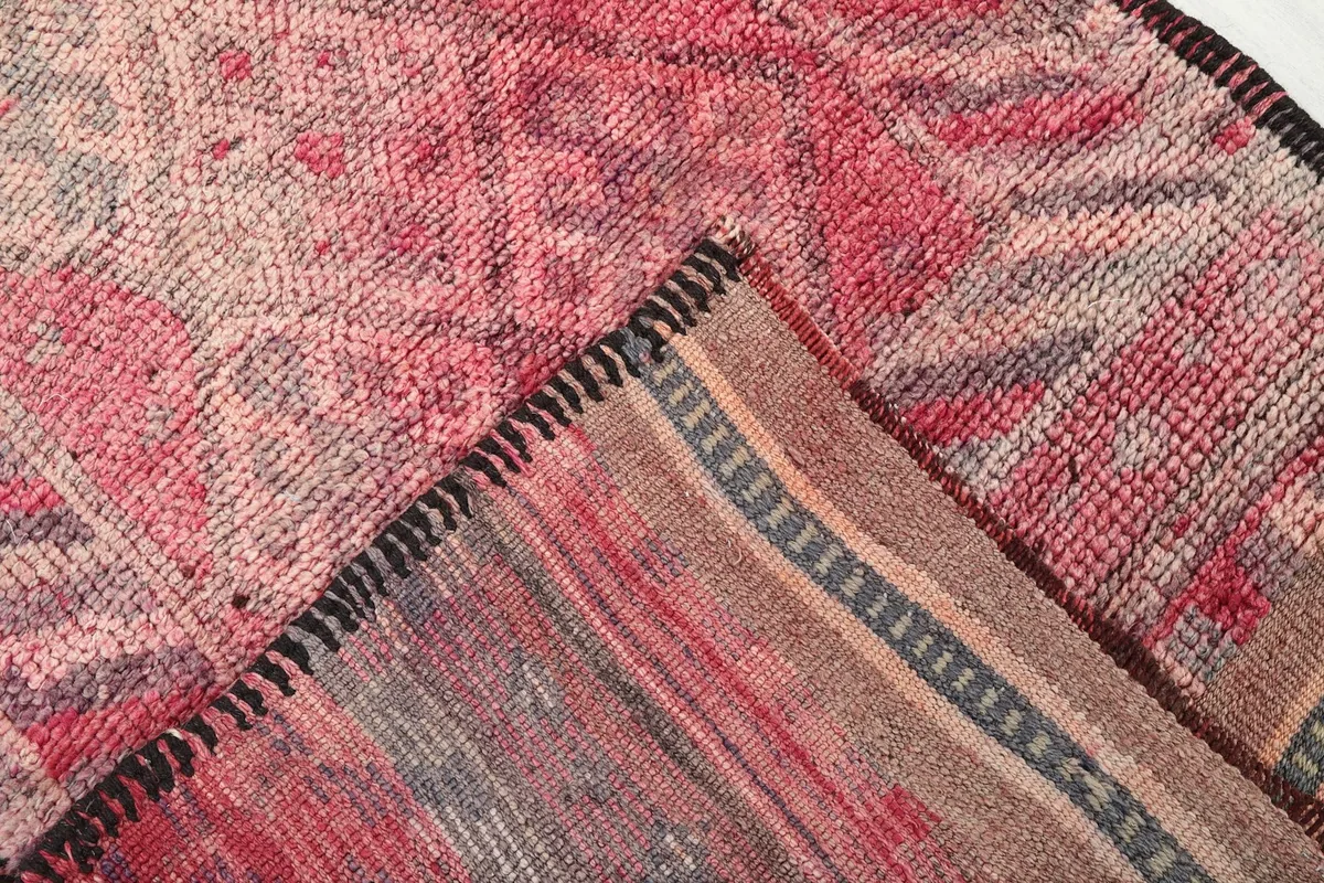 Corner folded back to show the cotton foundation and reverse side of the hand-knotted vintage rug.