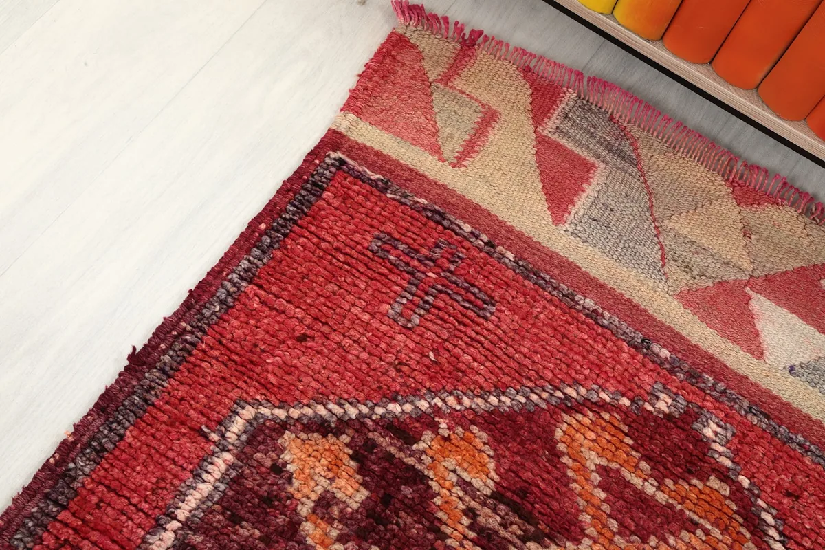 Corner detail of the rug, illustrating the transition from pile to the flat-woven end.