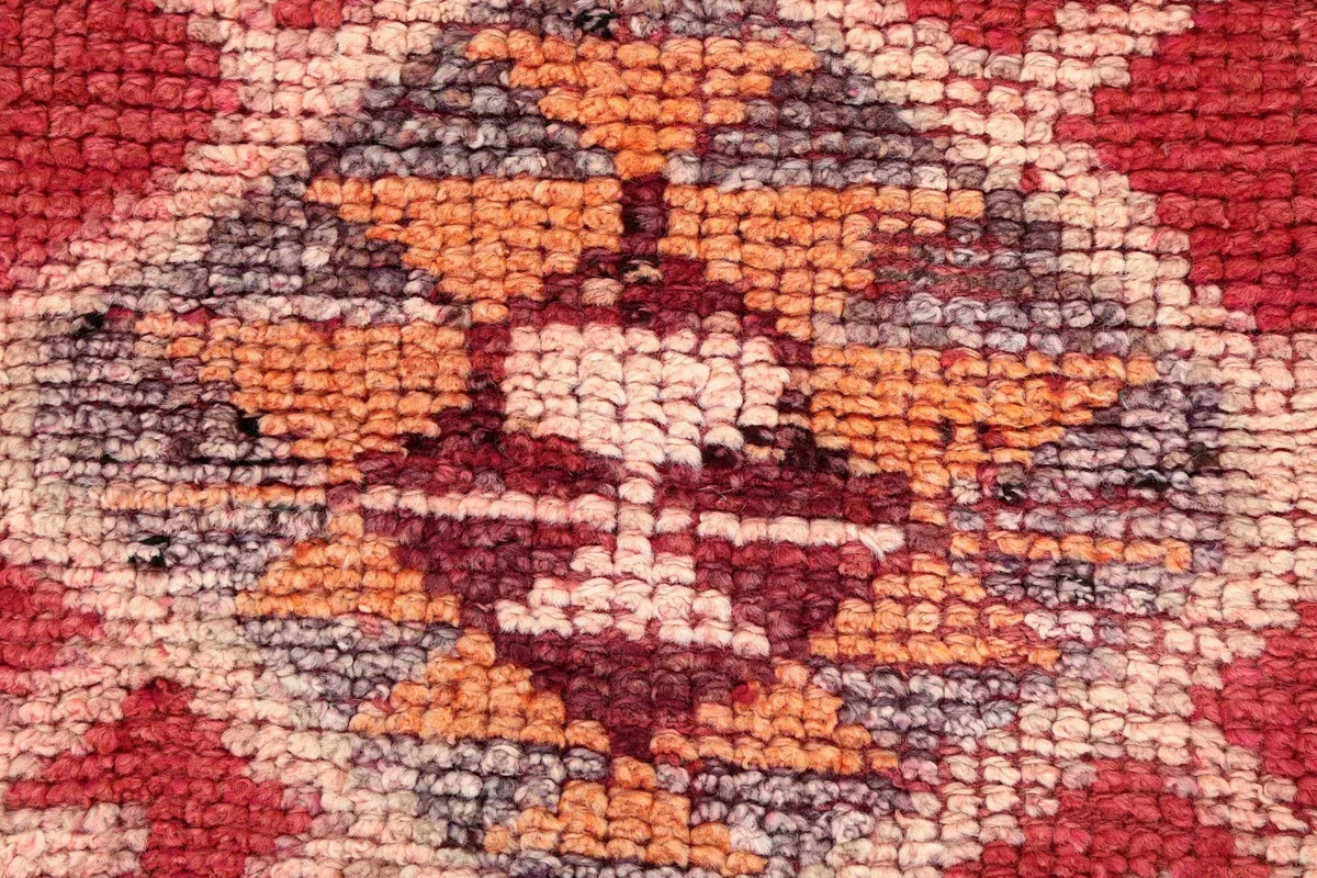 Macro view of the wool pile texture and the intricate colors within a central motif.