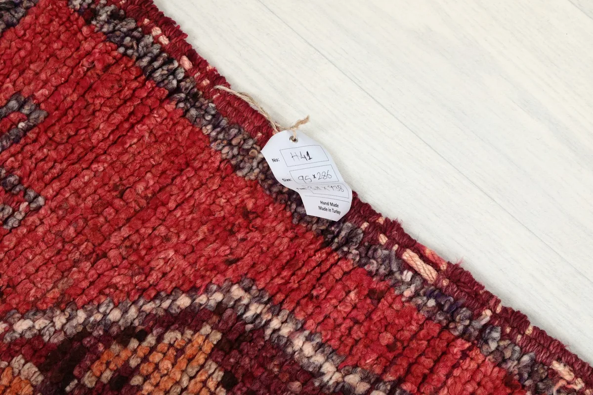 Corner of the rug with a product tag, showing the texture of the wool pile.